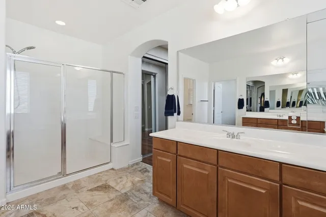 a bathroom with a sink double vanity granite tub shower and a mirror