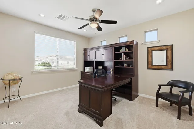 a bedroom with a bed a chair and a large window