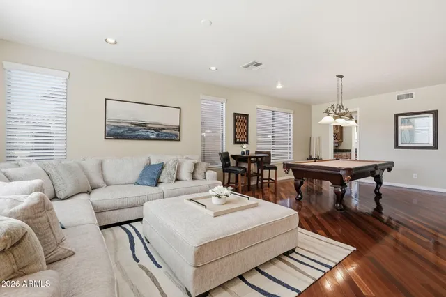 a living room with a table chairs and a wooden floor