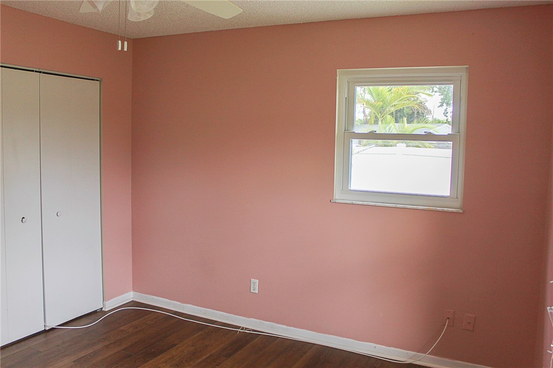 102 Cardinal Drive Sebastian, FL 32958 - Photo 25 of 34 an empty room with wooden floor and windows