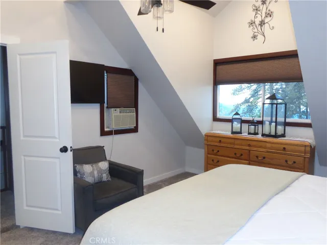 a bedroom with a bed and a large window