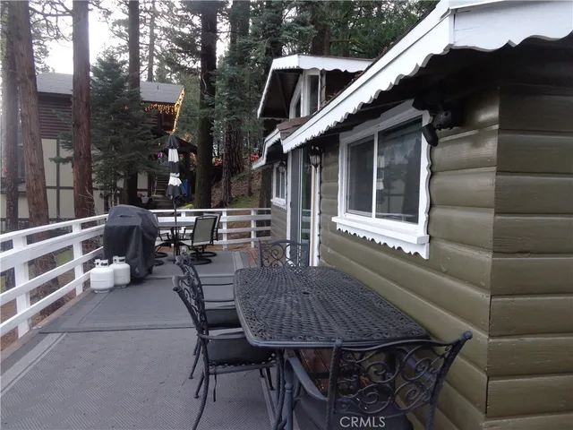 a view of a patio with table and chairs with wooden floor and fence