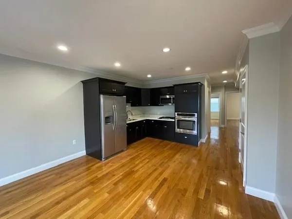 a view of an empty room with window and wooden floor