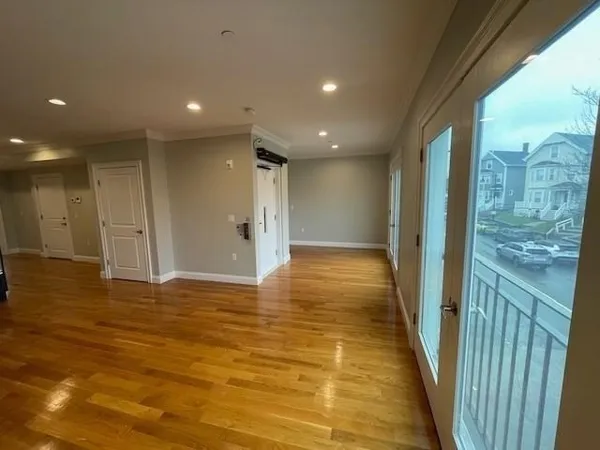 an empty room with wooden floor and windows