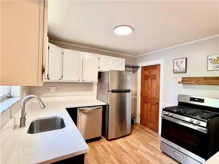 a kitchen with a refrigerator sink and cabinets