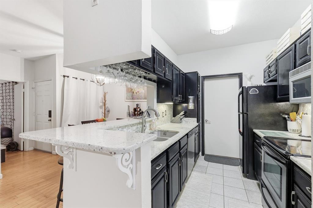 5619 Preston Oaks Road, Unit 305 Dallas, TX 75254 - Photo 12 of 35 a kitchen with stainless steel appliances granite countertop a sink stove and refrigerator