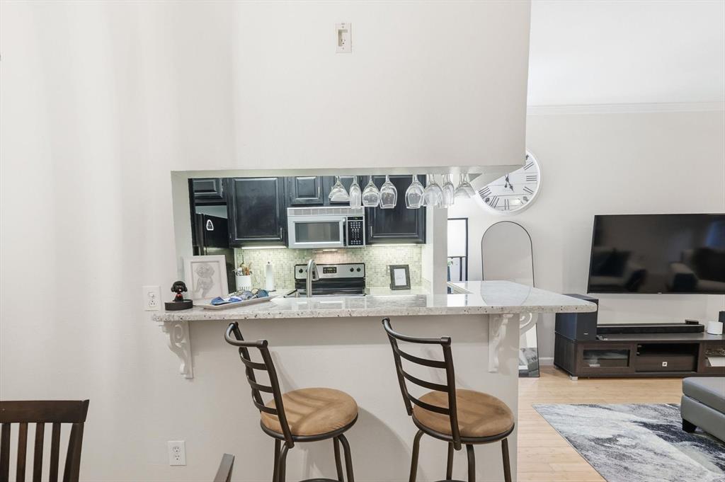 5619 Preston Oaks Road, Unit 305 Dallas, TX 75254 - Photo 9 of 35 a kitchen with stainless steel appliances a microwave a stove and white cabinets