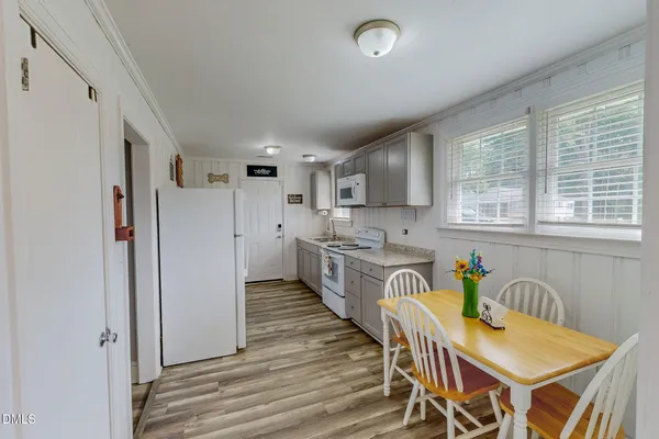 a kitchen with stainless steel appliances kitchen island granite countertop a refrigerator a stove a sink dishwasher with a dining table and chairs