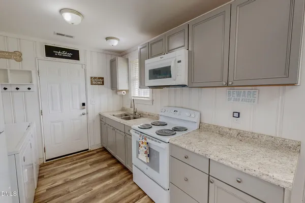 a kitchen with stainless steel appliances granite countertop a stove a sink and a white cabinets