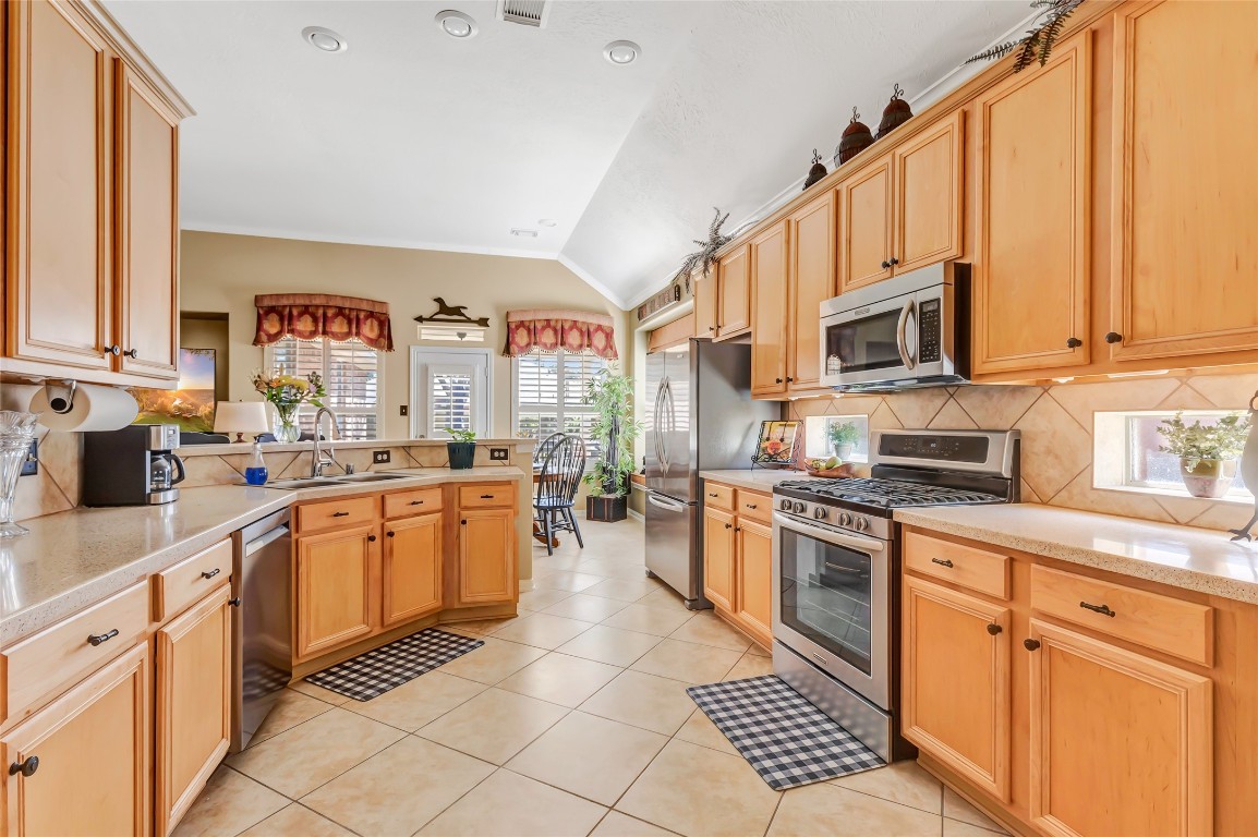 25605 Dartmaker Court Porter, TX 77365 - Photo 12 of 34 a kitchen with stainless steel appliances granite countertop a stove top oven a sink dishwasher and a microwave oven on the blue kitchen countertops