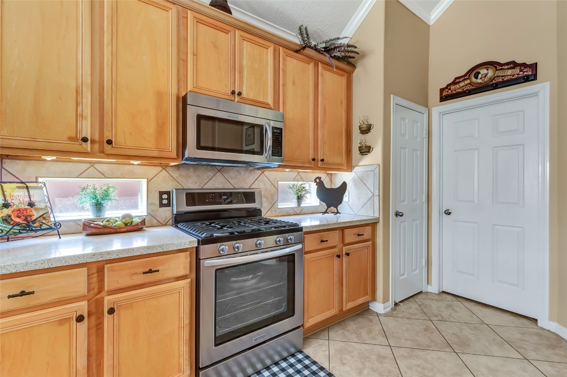 25605 Dartmaker Court Porter, TX 77365 - Photo 14 of 34 a kitchen with stainless steel appliances granite countertop a stove a sink and a microwave