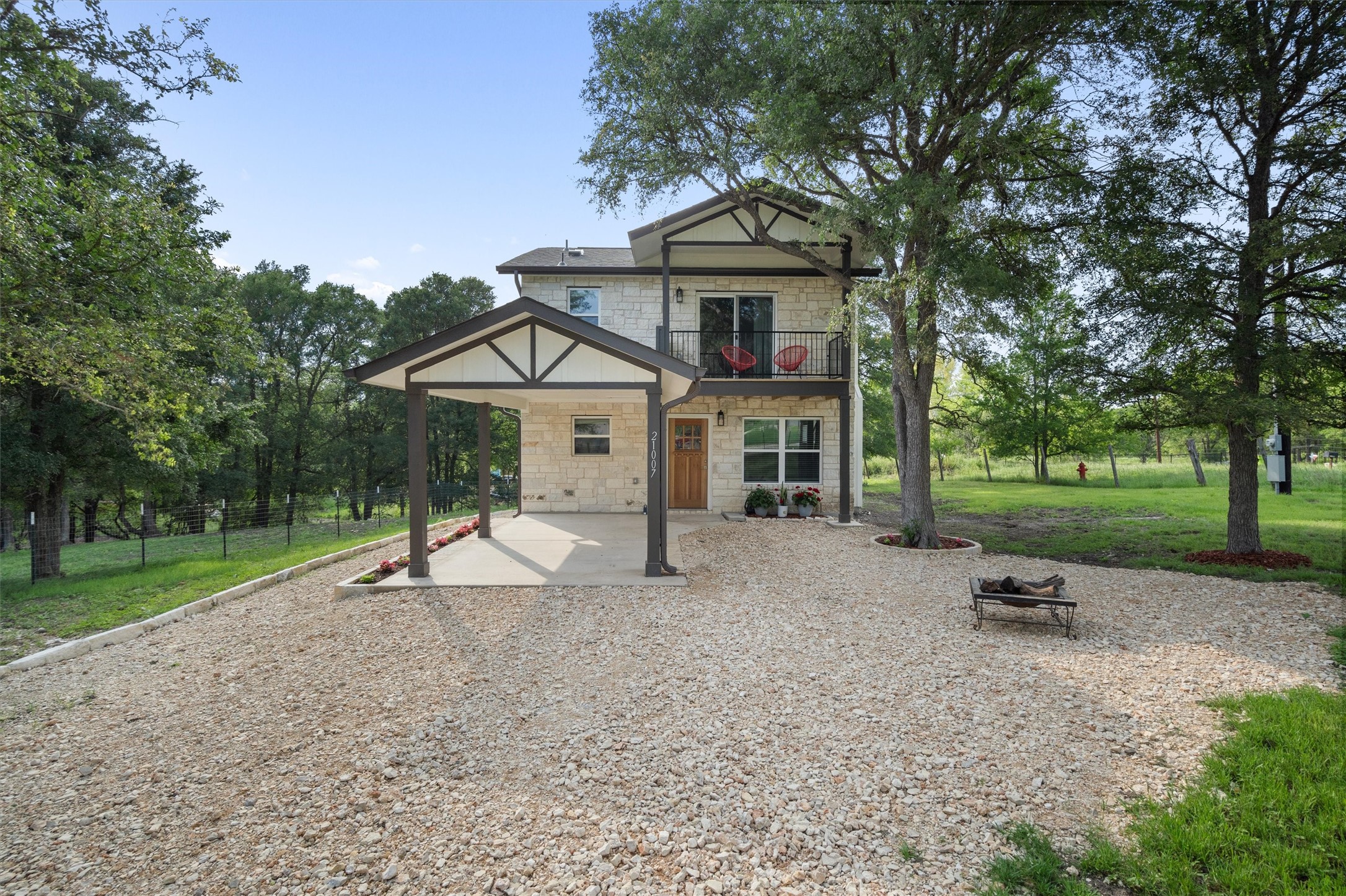 21007 Coleman Branch Creek Road Manor, TX 78653 - Photo 1 of 31 Front exterior surrounded by mature trees in a peaceful rural setting.