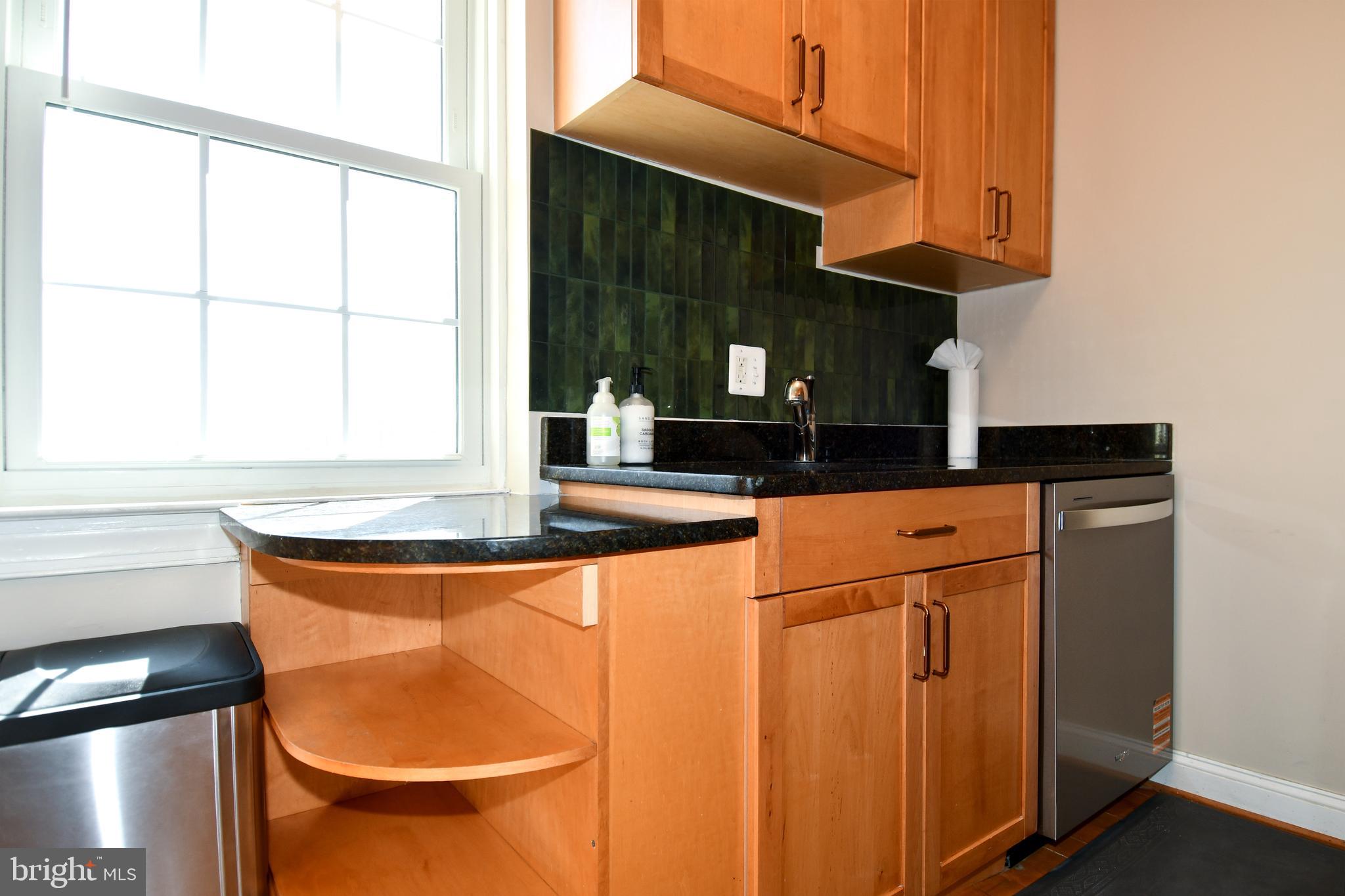 2625 3rd Street Northeast, Unit 301 Washington, DC 20002 - Photo 11 of 21 a kitchen with granite countertop a sink a stove and cabinets