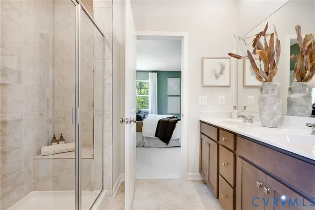 a en suite bathroom with a double vanity sink a mirror and shower