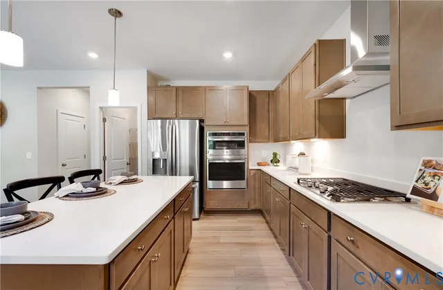 a kitchen with kitchen island stainless steel appliances a sink stove and refrigerator