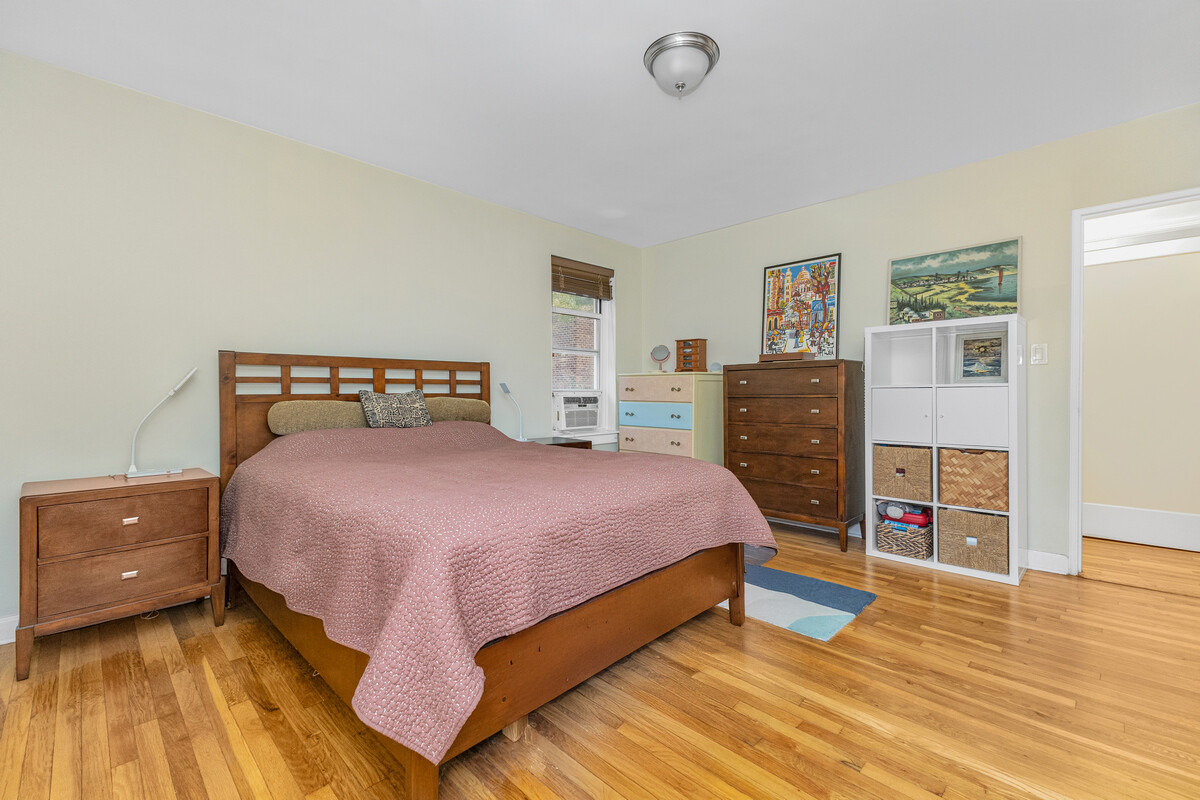 67-07 Yellowstone Boulevard, Unit 3H Queens, NY 11375 - Photo 2 of 6 a bedroom with a bed and wooden floor