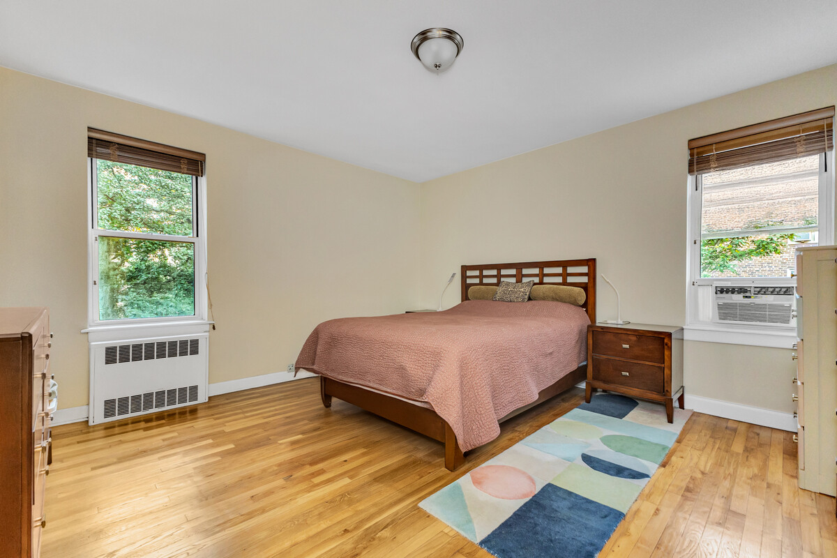 67-07 Yellowstone Boulevard, Unit 3H Queens, NY 11375 - Photo 3 of 6 a bedroom with a bed and wooden floor