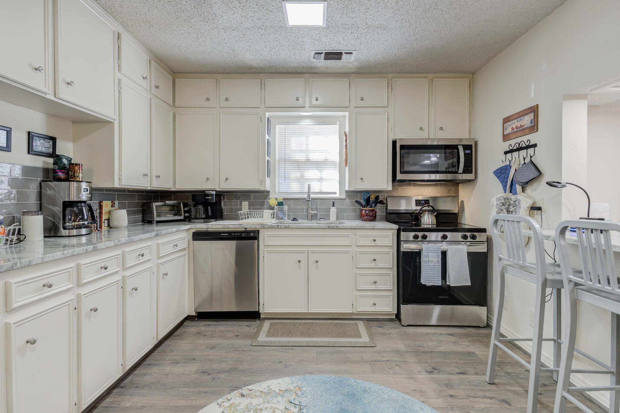 2822 23rd Street Lubbock, TX 79410 - Photo 13 of 39 a kitchen with white cabinets sink and stainless steel appliances