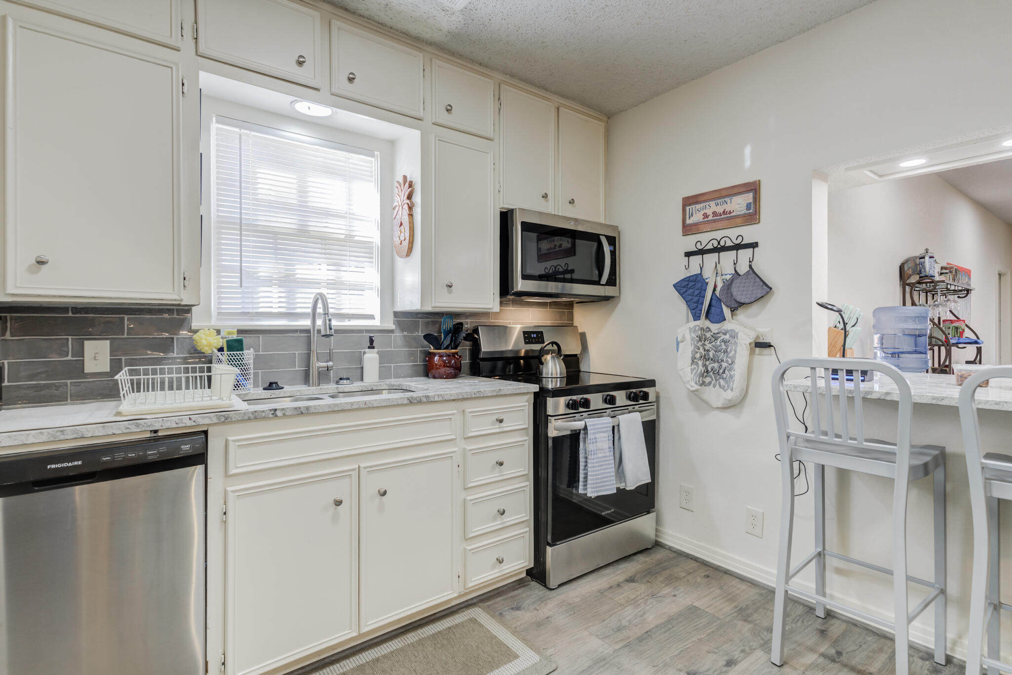 2822 23rd Street Lubbock, TX 79410 - Photo 14 of 39 a kitchen with stainless steel appliances granite countertop a sink a stove a refrigerator and cabinets