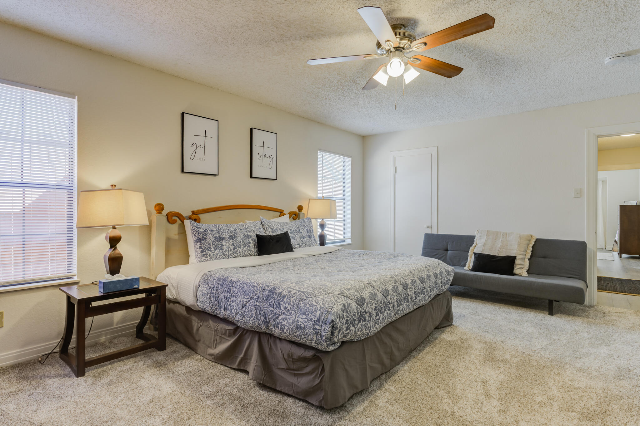 2822 23rd Street Lubbock, TX 79410 - Photo 29 of 39 a spacious bedroom with a bed a couch and a chandelier