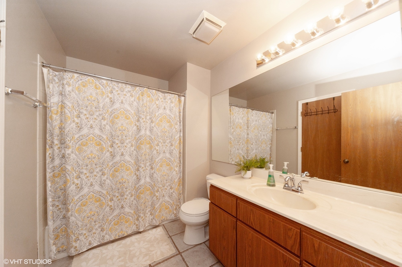 970 Ridgefield Lane, Unit 970 Wheeling, IL 60090 - Photo 8 of 10 a bathroom with a granite countertop sink toilet a mirror a vanity and shower
