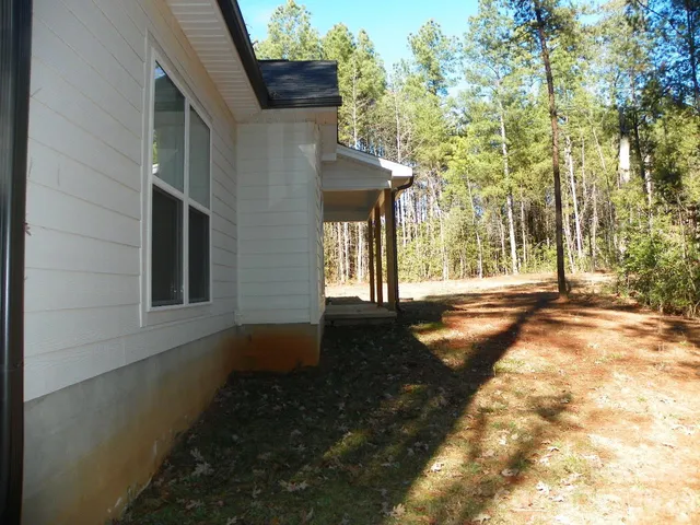 a view of a yard with plants and trees