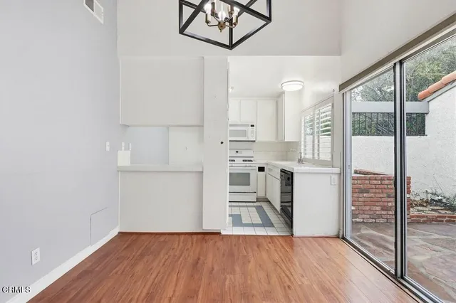 a view of a kitchen with wooden floor and electronic appliances