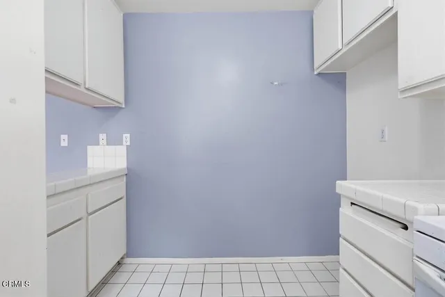 a utility room with cabinets washer and dryer