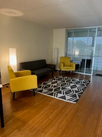 a living room with couch and a table with wooden floor