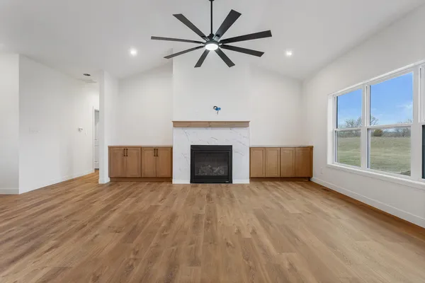 a view of a room with a ceiling fan and a fireplace