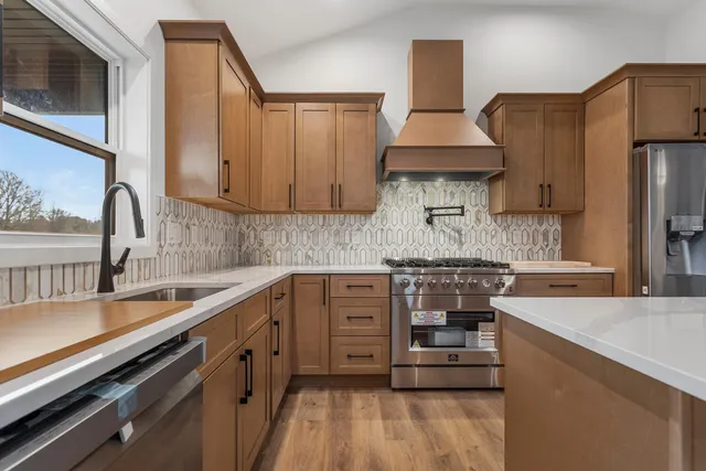 a kitchen with stainless steel appliances a sink stove and cabinets