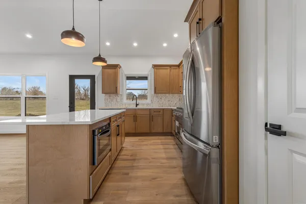 a kitchen with stainless steel appliances granite countertop a sink a stove and a refrigerator