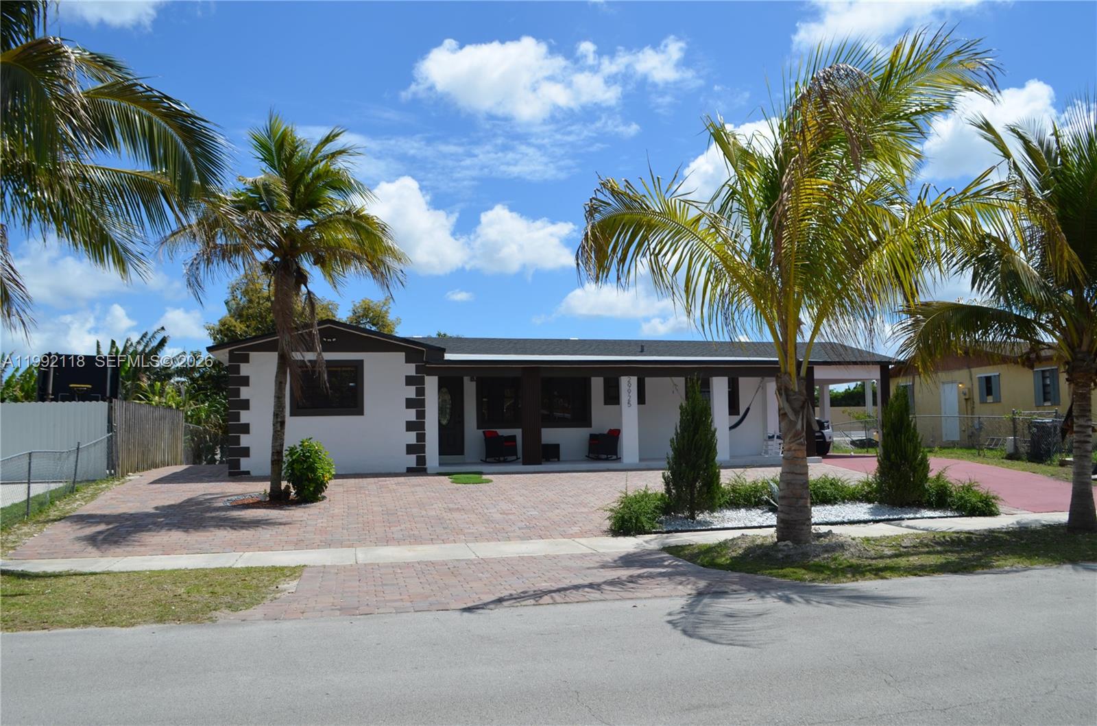 a view of a house with a yard and palm trees