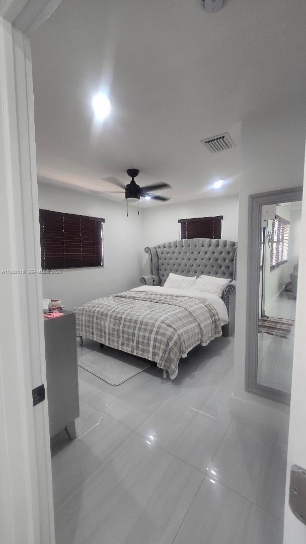 29925 Southwest 143rd Court Homestead, FL 33033 - Photo 11 of 40 a bedroom with a large bed and a chandelier