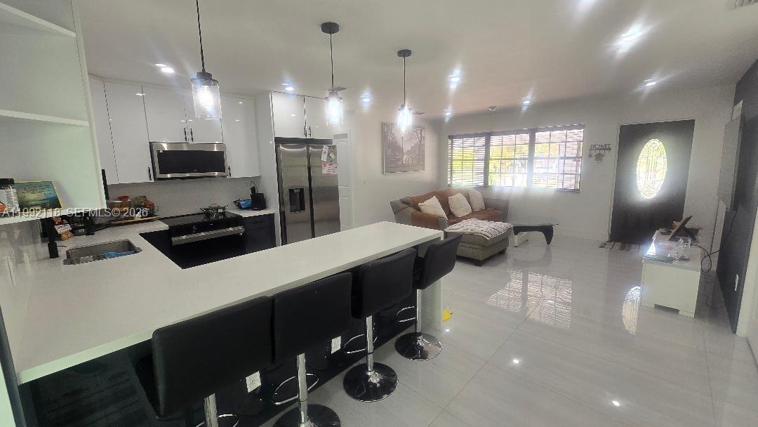 29925 Southwest 143rd Court Homestead, FL 33033 - Photo 38 of 40 a kitchen with a sink a counter and chairs