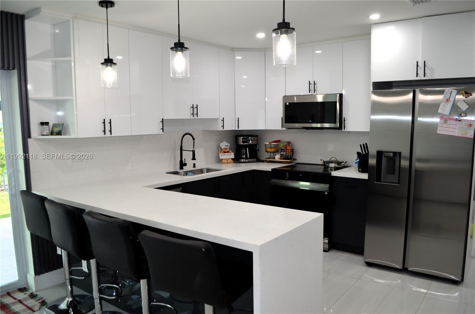29925 Southwest 143rd Court Homestead, FL 33033 - Photo 6 of 40 a kitchen with a sink a counter top space stainless steel appliances and cabinets
