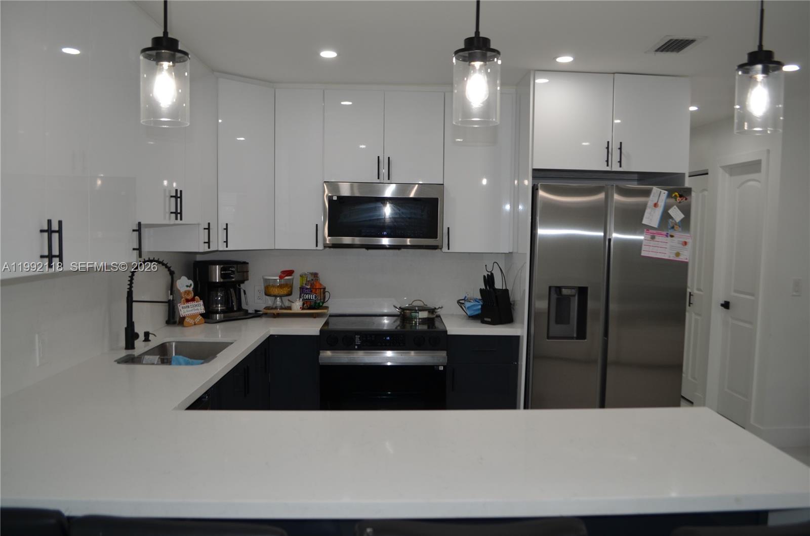 29925 Southwest 143rd Court Homestead, FL 33033 - Photo 8 of 40 a kitchen with stainless steel appliances a sink a refrigerator a stove a microwave and island