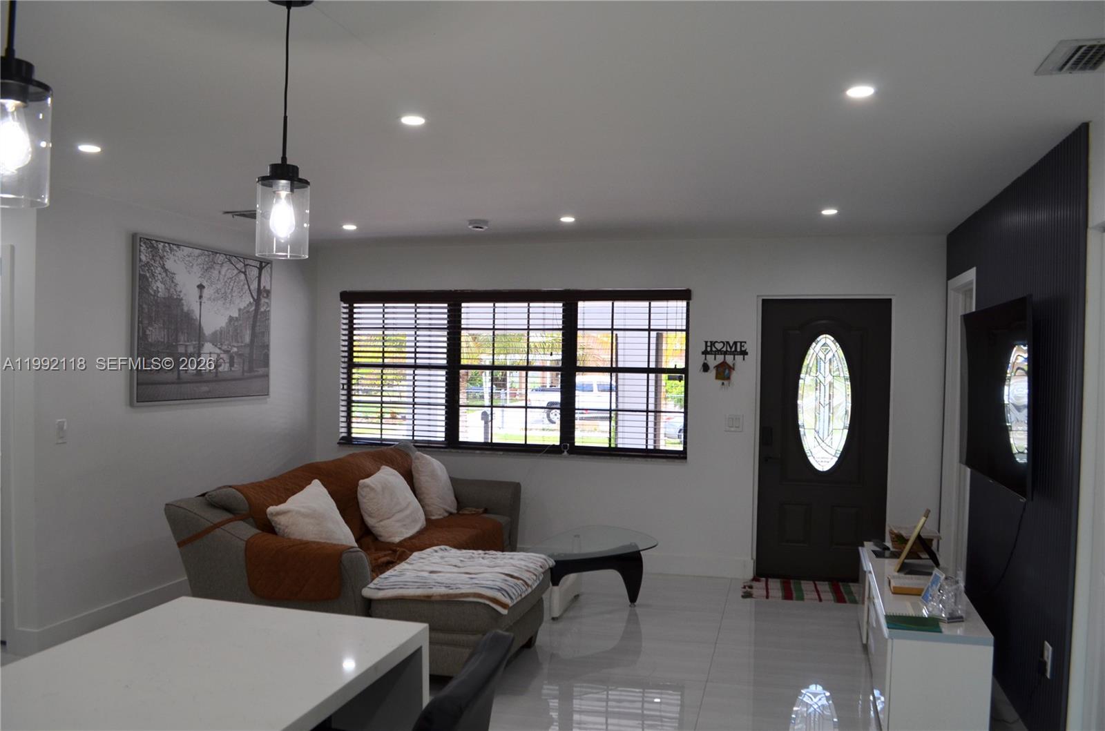 29925 Southwest 143rd Court Homestead, FL 33033 - Photo 9 of 40 a living room with furniture a mirror and a large window