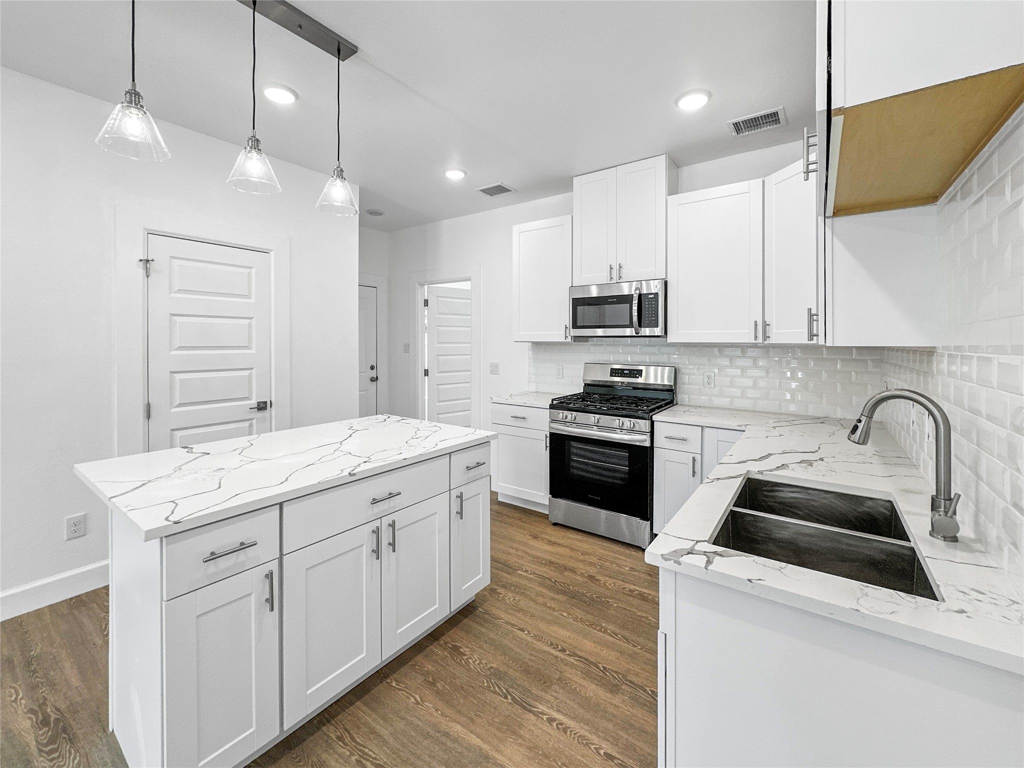 8141 Jeffery Street Houston, TX 77028 - Photo 5 of 27 a kitchen with a sink white cabinets and stainless steel appliances