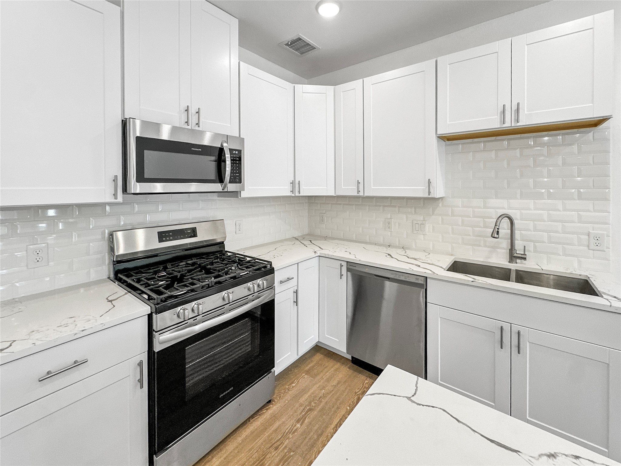 8141 Jeffery Street Houston, TX 77028 - Photo 7 of 27 a kitchen with white cabinets and stainless steel appliances