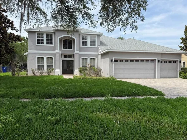 a front view of a house with a garden and yard