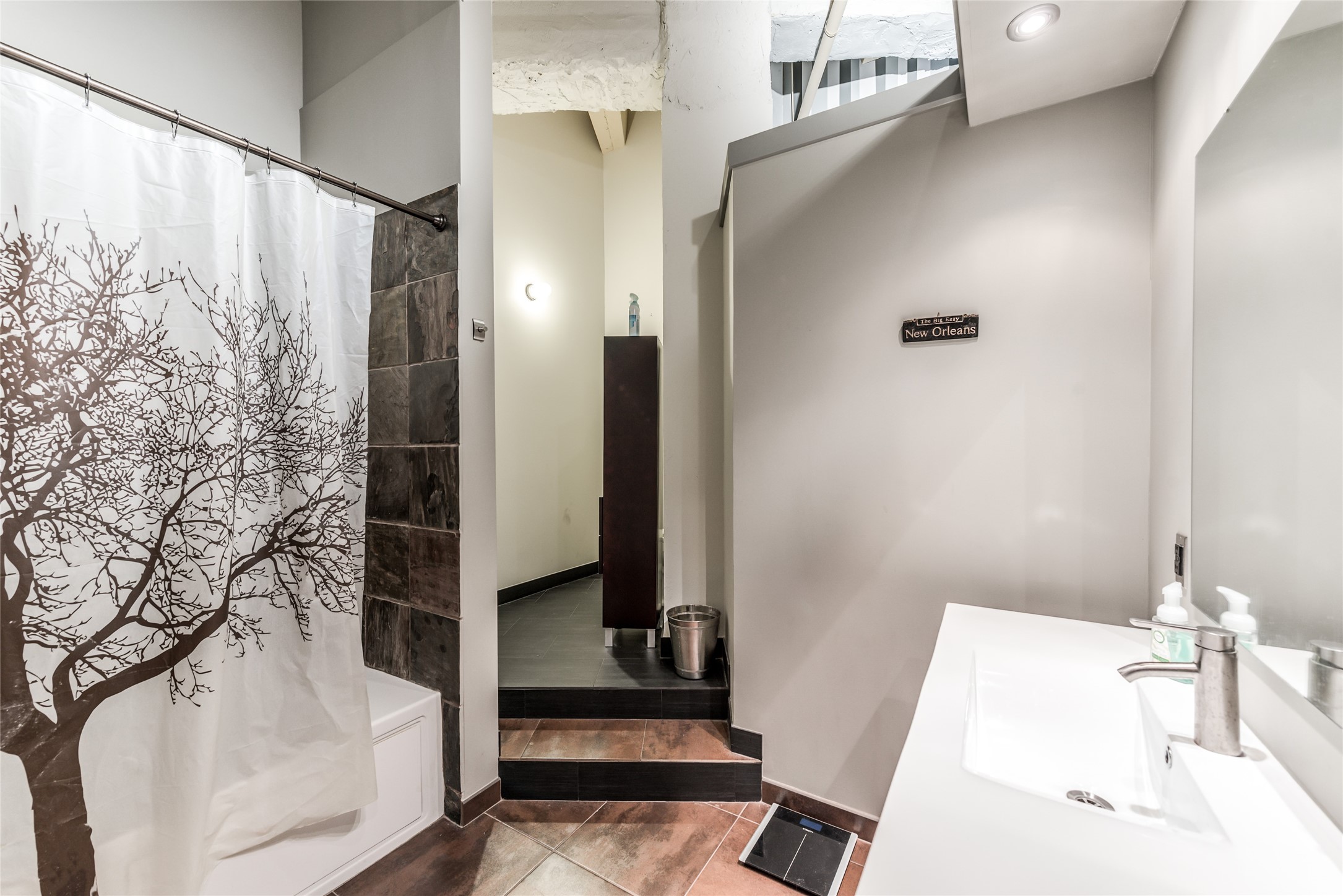 705 Main Street, Unit 215 Houston, TX 77002 - Photo 16 of 36 Secondary Bathroom features a modern design with slate tile accents, and a sleek white vanity.