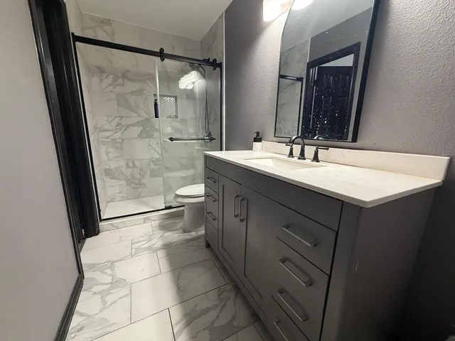 a bathroom with a double vanity sink mirror and shower