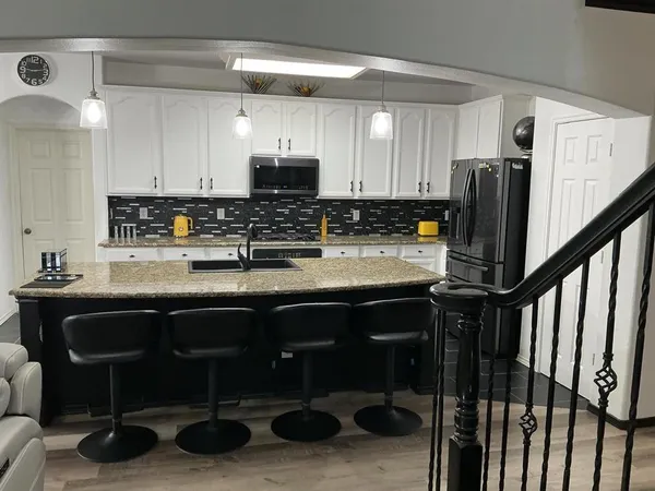 a kitchen with stainless steel appliances granite countertop a sink a stove a refrigerator and cabinets