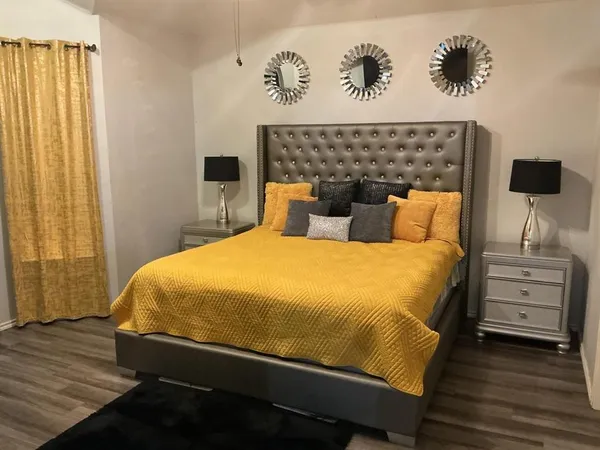 a bedroom with a bed and a flat tv screen on dresser