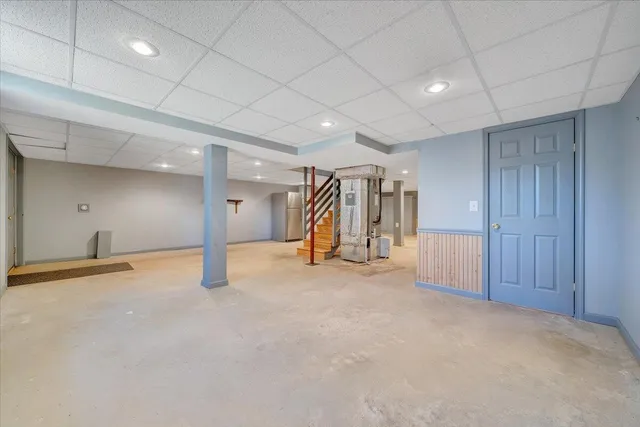 a backyard of a house with large trees and wooden fence