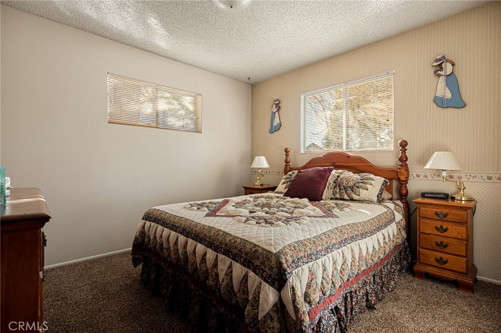 1164 Bear Springs Road Rimforest, CA 92378 - Photo 15 of 18 a bedroom with a bed a dresser with wooden floor
