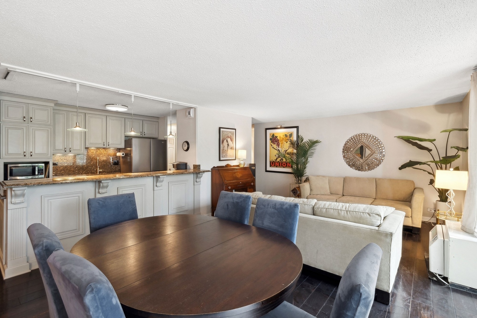 71 East Division Street, Unit 401 Chicago, IL 60611 - Photo 3 of 21 a living room with couches a dining table and kitchen view with wooden floor