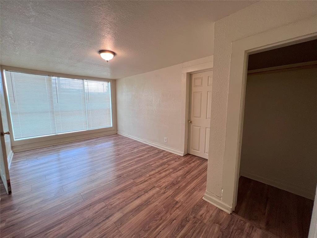 317 Ritchey Street Gainesville, TX 76240 - Photo 9 of 13 Unfurnished bedroom with a textured ceiling, wood finished floors, and baseboards