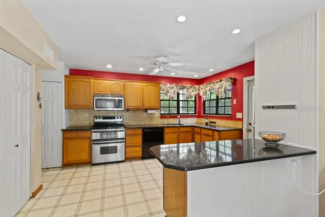 a kitchen with stainless steel appliances granite countertop a sink counter space cabinets and a stove